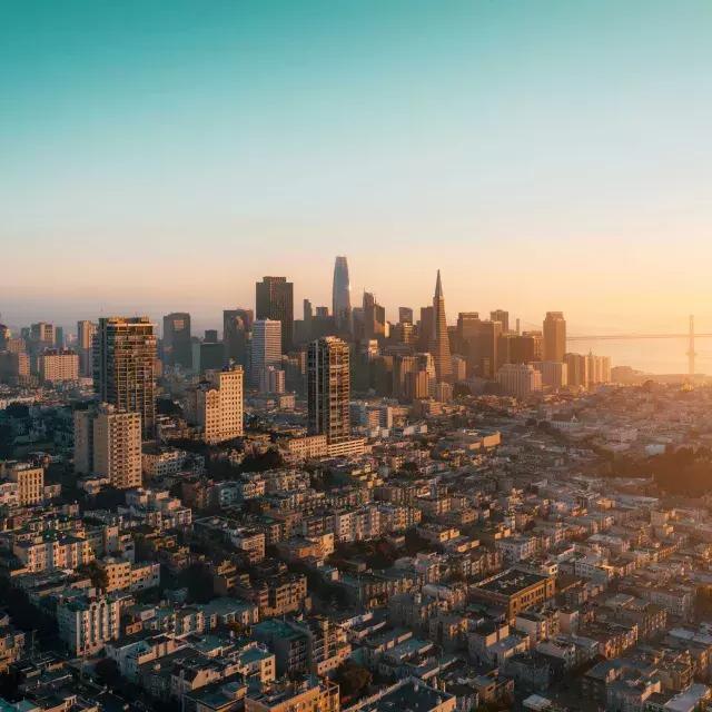 The skyline of San Francisco is seen from the air in a golden light.